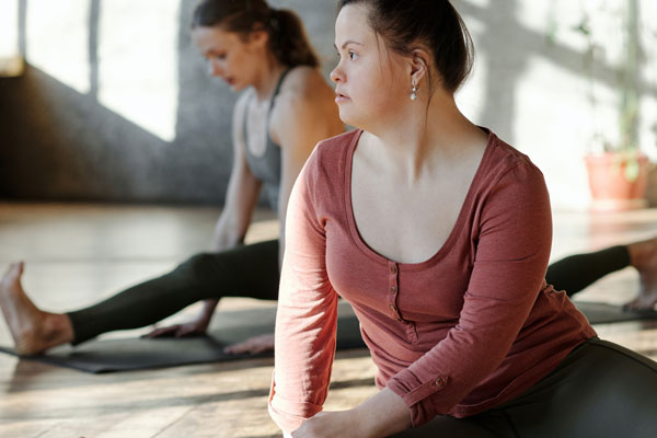 A girl sitting on a yoga matt during an exercise class.