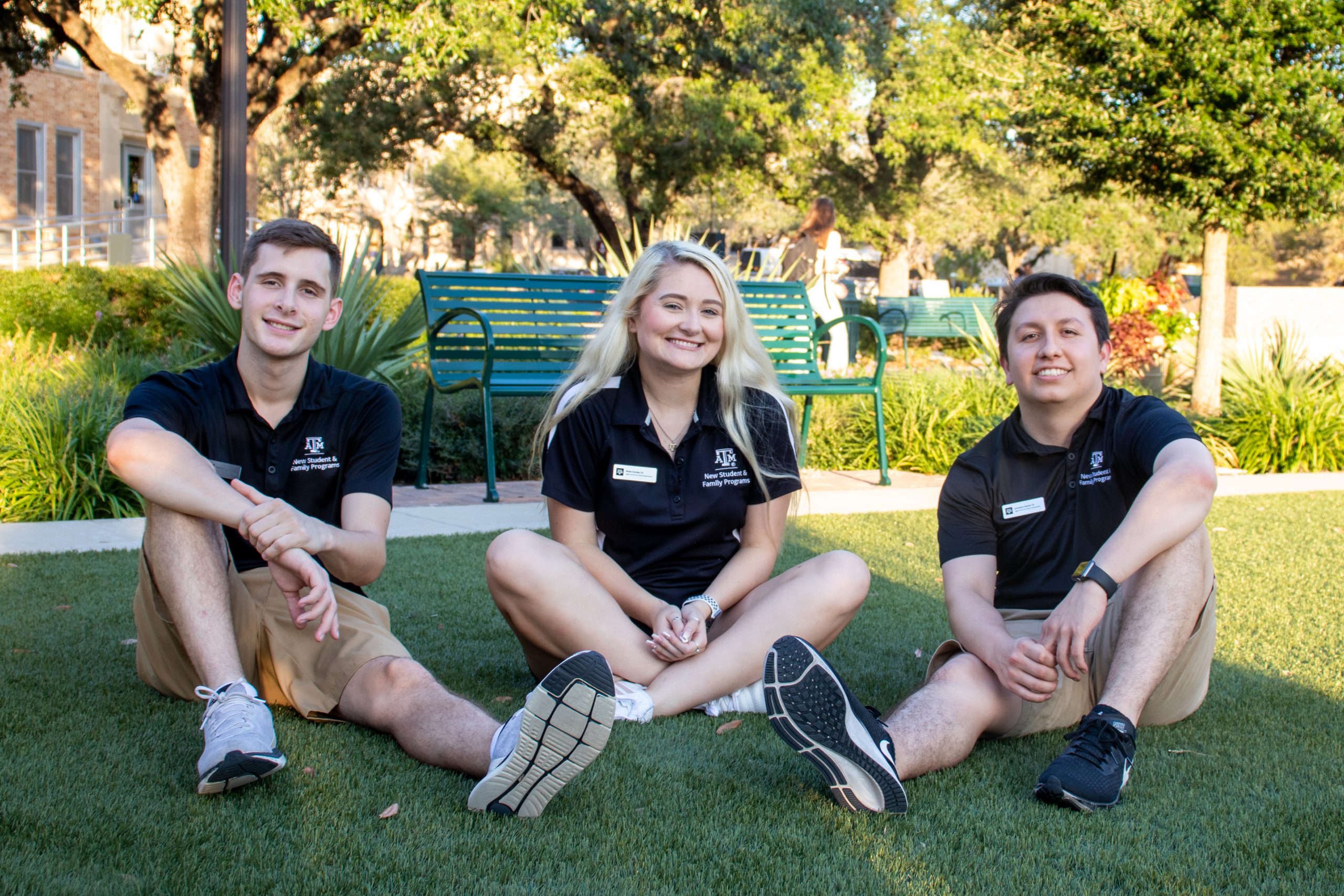 Texas A&M student leaders sitting on a grassy area on campus
