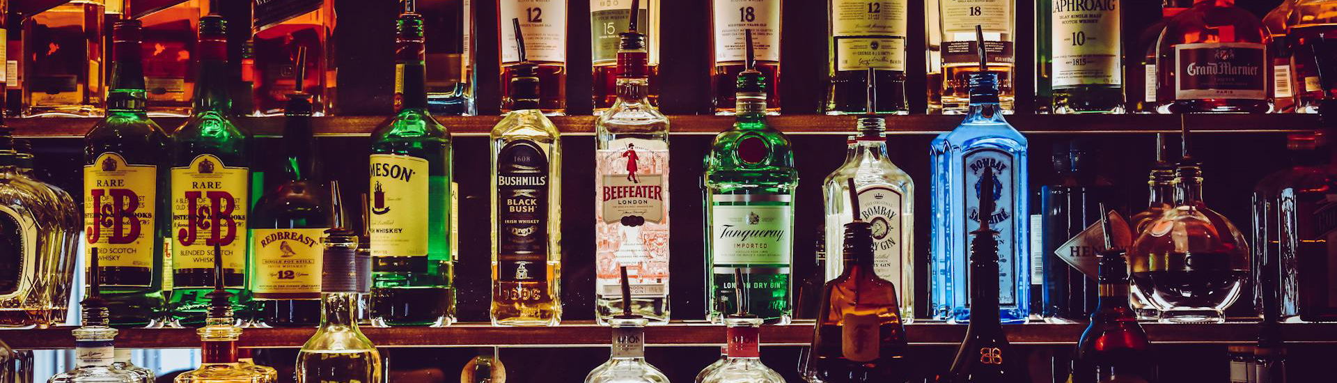 Shelves of alcohol in a bar setting.