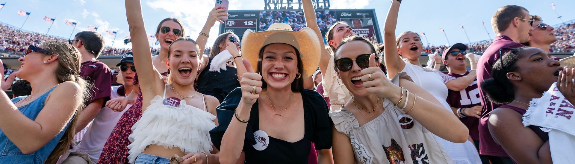 Students smiling at a Texas A&M Football game.