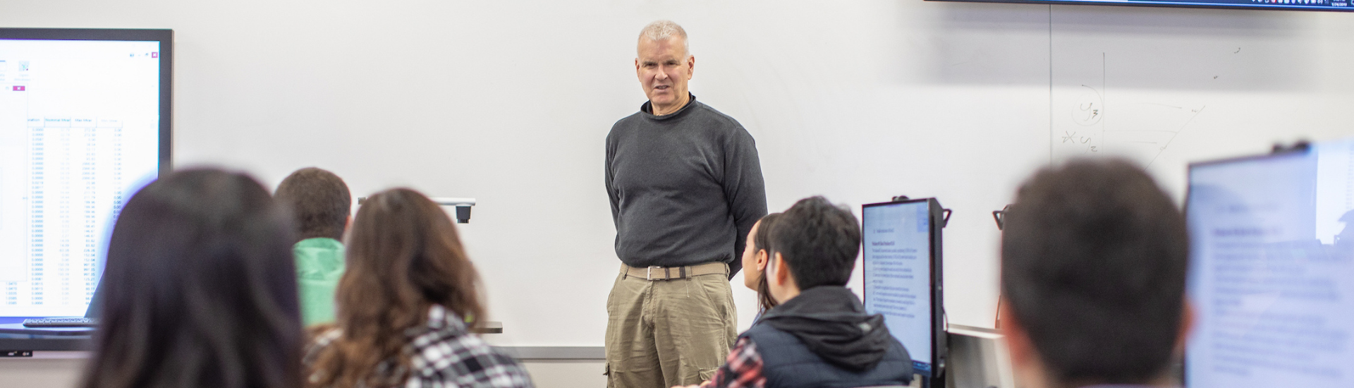 Texas A&M professor standing at the front of a classroom in Zachry lecturing students.